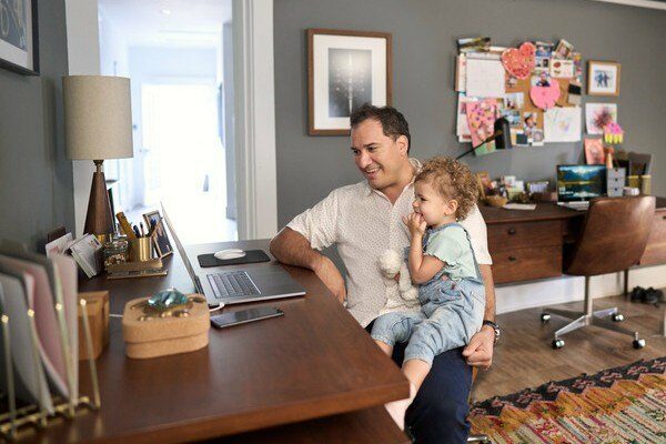 Father sitting at a desk holding his daughter