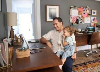 Father sitting at a desk holding his daughter