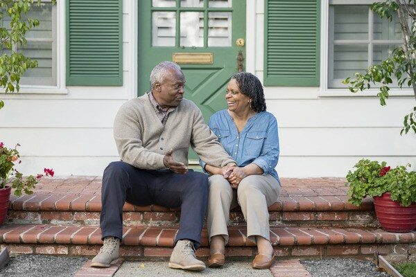 Couple sitting on the front steps of their home