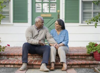Couple sitting on the front steps of their home