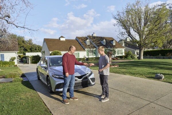 Man Handing Car Keys to Teenager