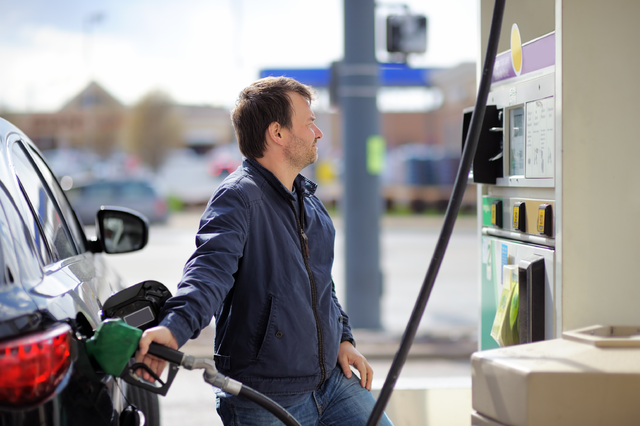 Man fills car with gas at station.