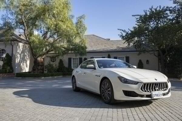 Luxury car in front of large home