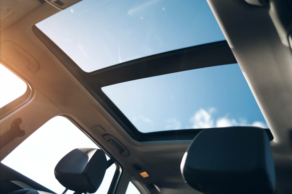 The sun streams in through a car sunroof.