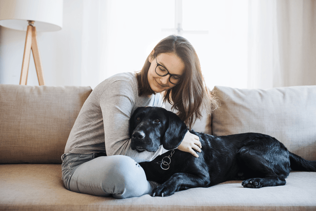 Woman cuddling pet in apartment.