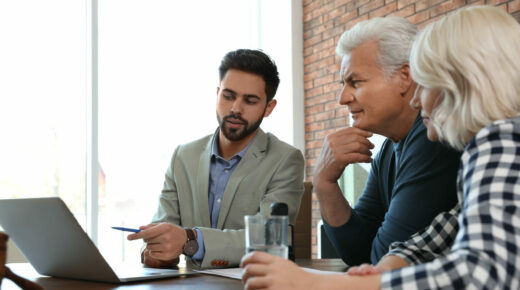 Photo of a financial advisor working with a mature couple in an office.