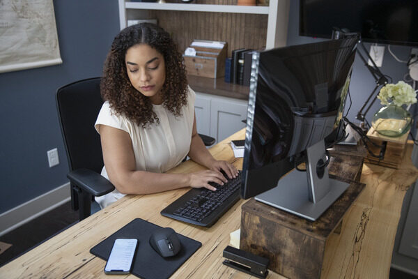 Woman working at her desk and looking at her phone