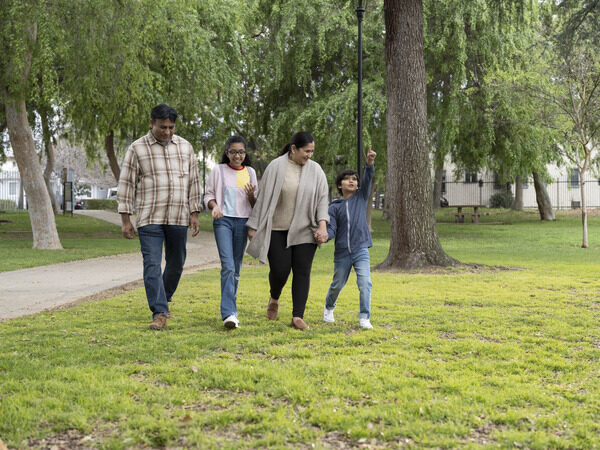 Family walking together through a park.