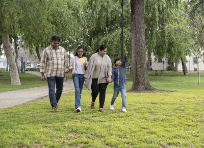Family walking together through a park.