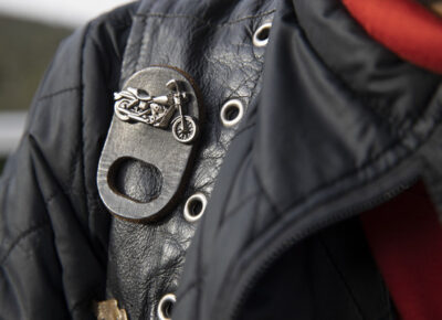 Closeup of a black leather jacket and motorcycle pin