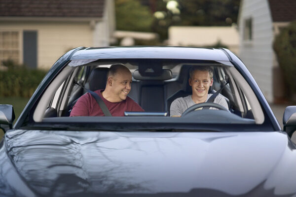 Two men sitting in a black car.