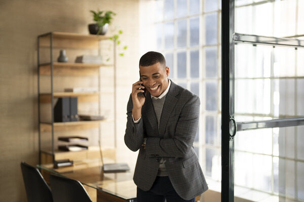 Man in his office smiling on the phone