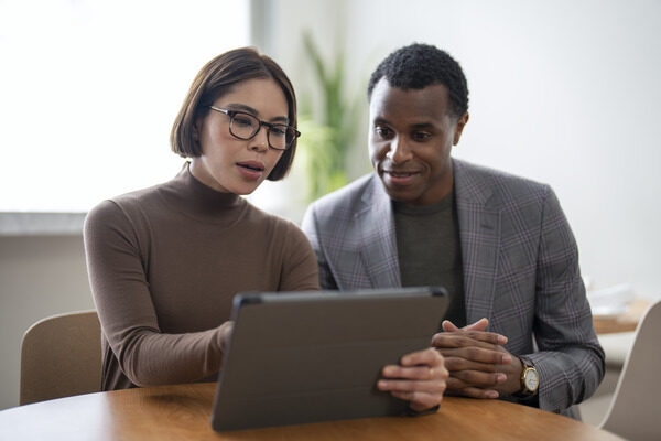 Woman and man at work looking at a tablet