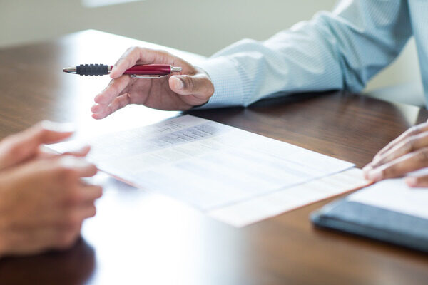 People's hands over paper and a notepad