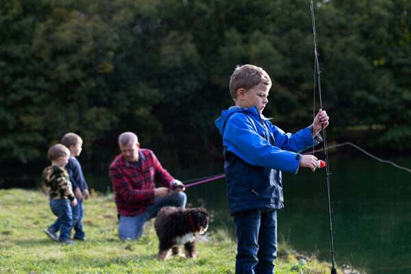 Father fishing with his sons and dog