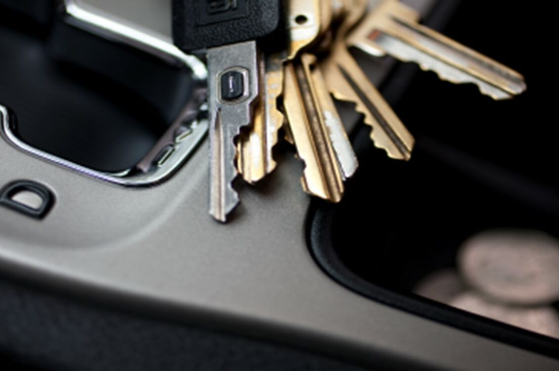 A set of keys sitting on the console of a car.