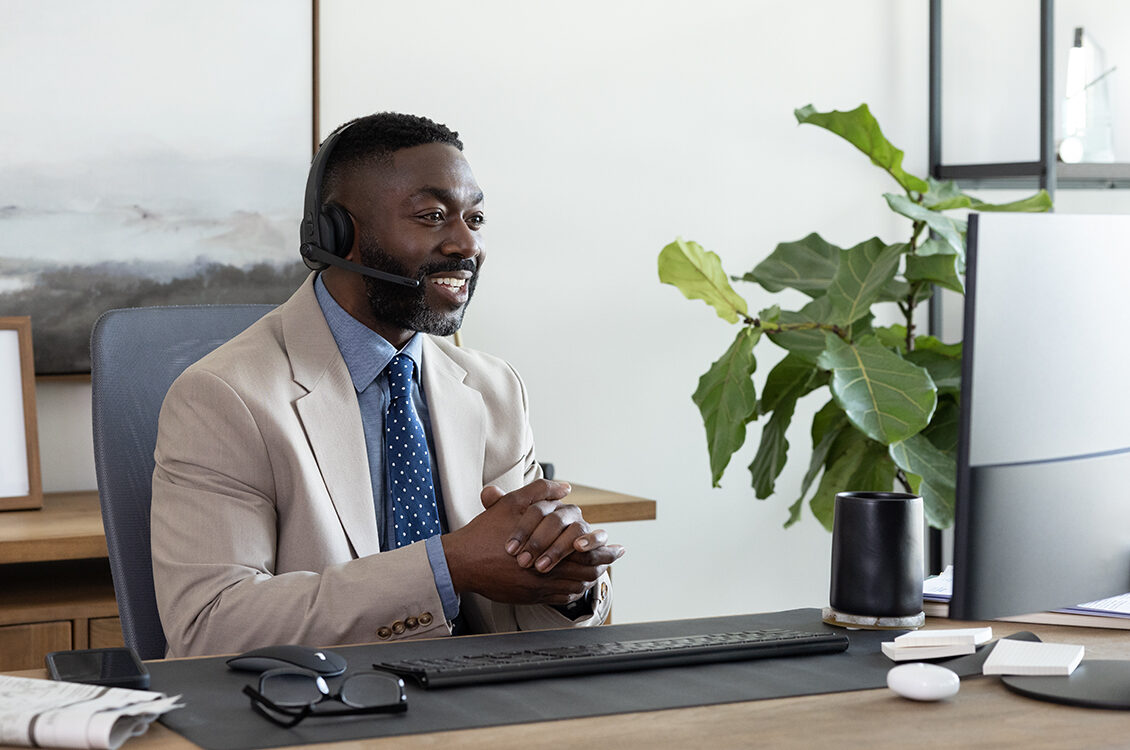 Man sitting at his work desk on a virtual meeting.