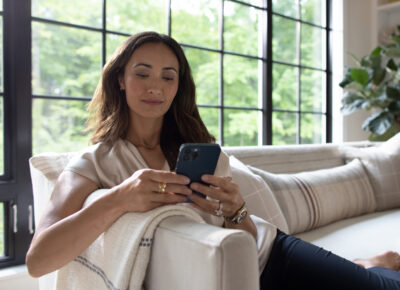 Woman sitting on the couch and looker at her phone.