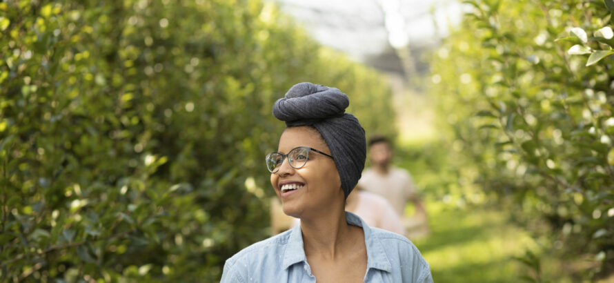 A woman exploring outside while holding papers in her hands.