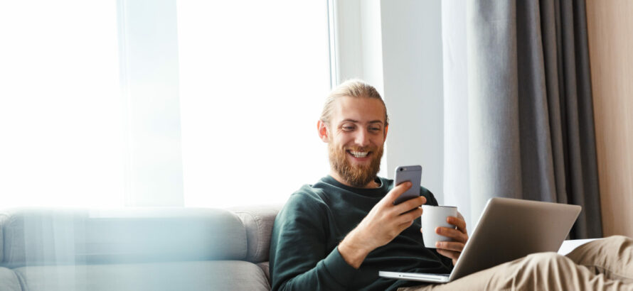 A man checking his phone while sitting on the couch.