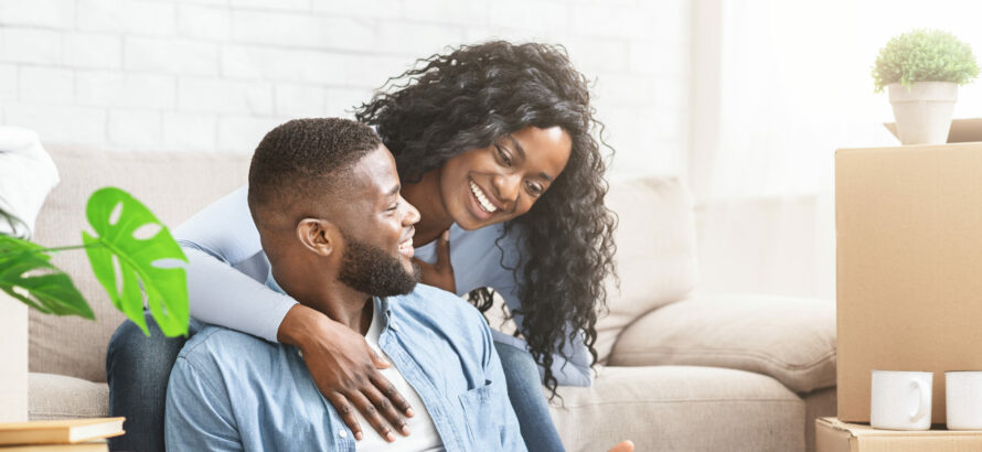 A happy couple checking out information on a laptop.