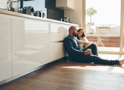 A couple sitting on the kitchen floor.