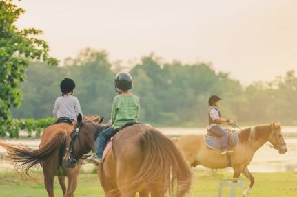 Three children riding horses.
