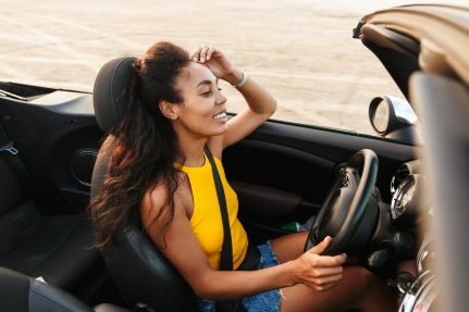 A woman driving a convertible.