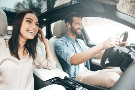 A couple laughs while driving.