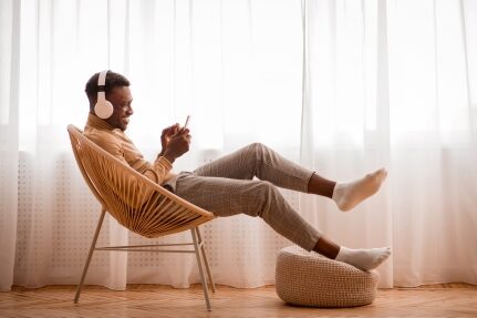 A man reading about PWC maintenance on his phone while wearing headphones.