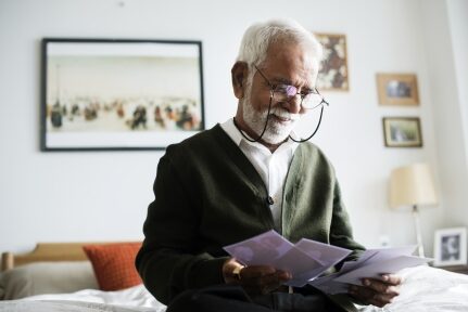 A man reads papers in his home.