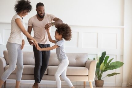 A family dances in a living room.