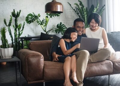 A family apartment hunts on a computer on their couch.
