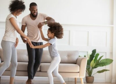 A family dancing together in the living room.