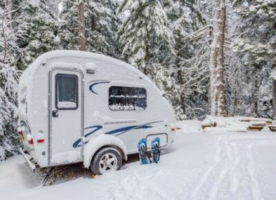 A travel trailer parked in the snow.