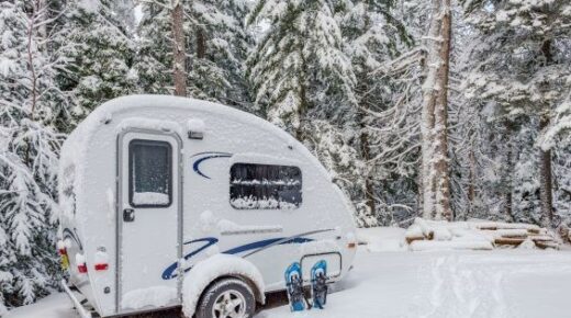 A travel trailer parked in the snow.