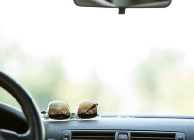 Sunglasses resting on the dashboard of a car.