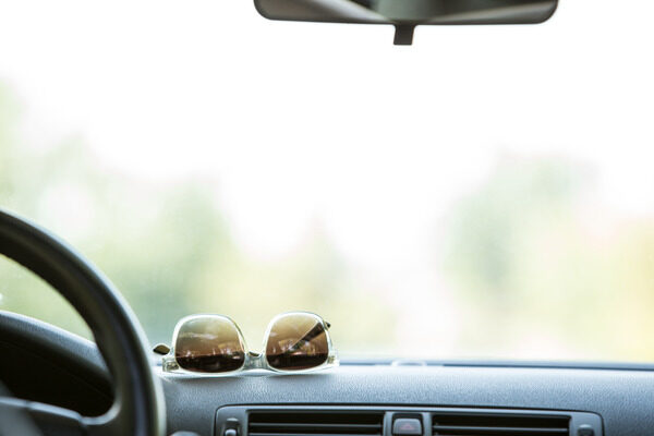 Sunglasses resting on the dashboard of a car.