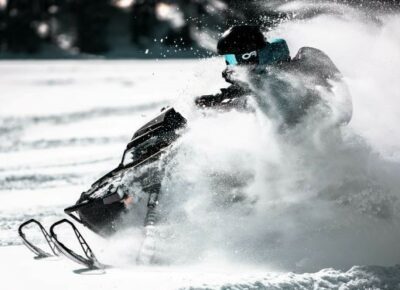 A person riding a snowmobile on the trail.