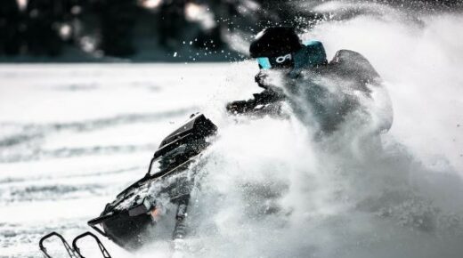 A person riding a snowmobile on the trail.