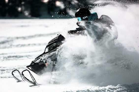 A person riding a snowmobile on the trail.