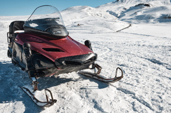 A snowmobile parked on the snow.