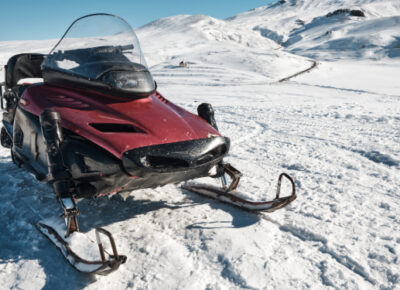 A snowmobile parked on the snow.