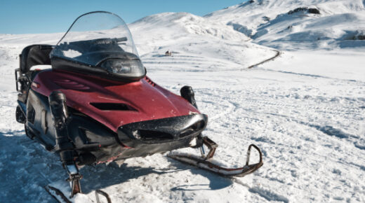 A snowmobile parked on the snow.