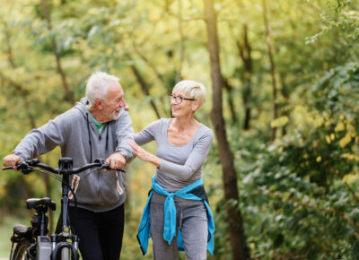 A senior couple outside with a bike.