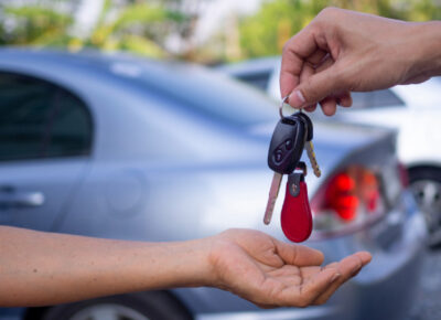 A person handing another person a set of car keys.