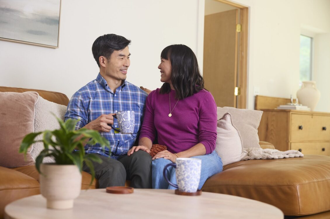 couple sitting on couch smiling
