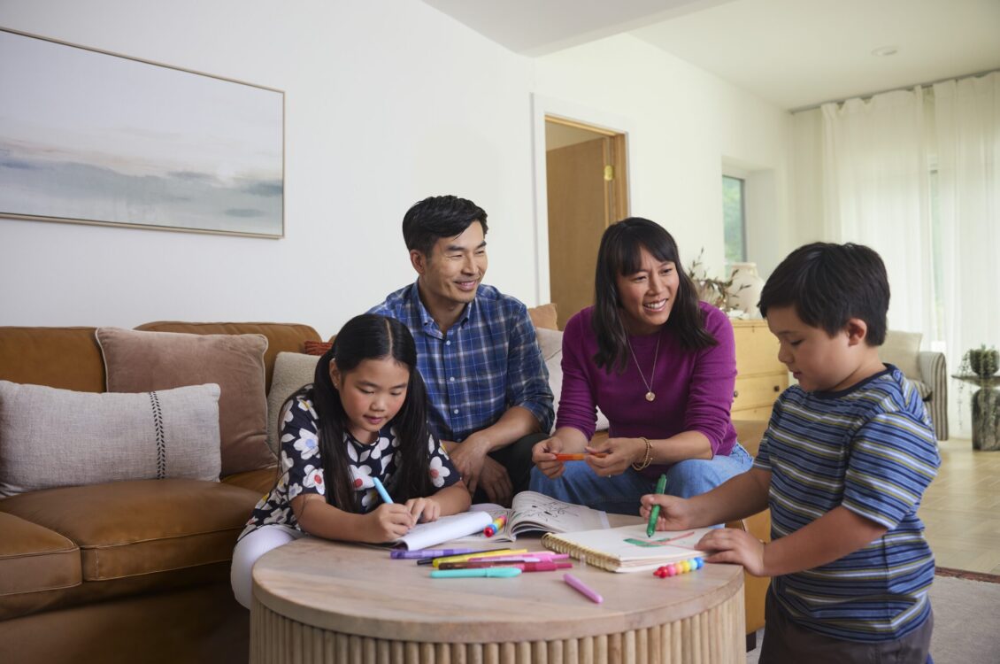 family coloring together and smiling