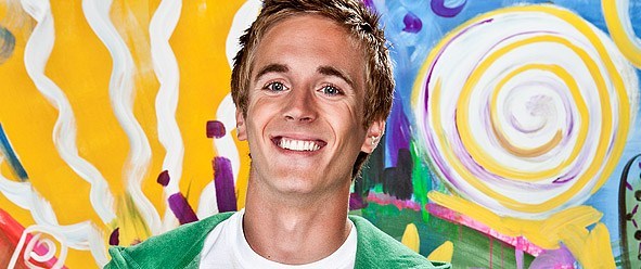 a person smiling in front of a colorful background